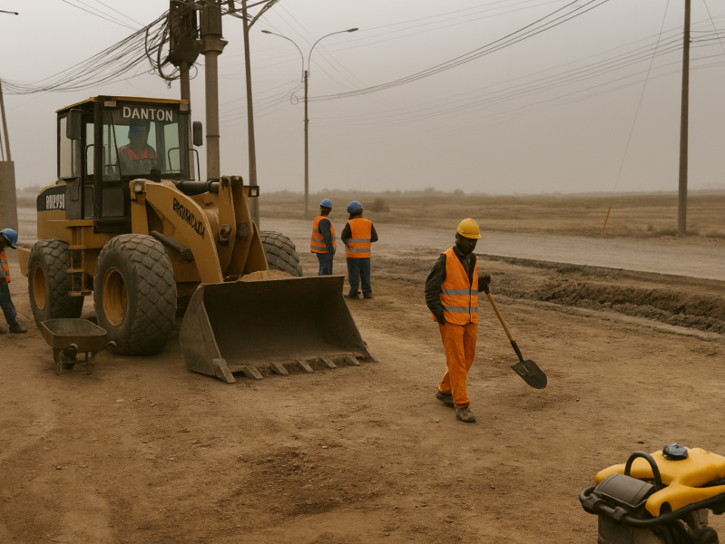 Cargador frontal y obreros preparando una calle para pavimentar